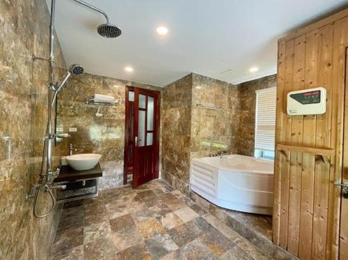 a bathroom with a tub and a sink at Flamigo Dai Lai Resort - Happy Villa in Ngọc Quang