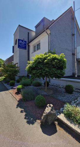 a building with a tree in front of it at Ferienwohnung in Wilnsdorf OT Wilden neu erstellt & hochwertig in Wilnsdorf