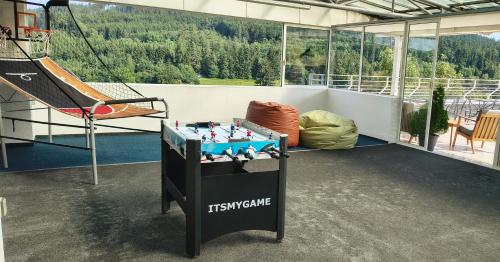 a room with a table with a game on a balcony at Hotel Adamantino in Luhačovice