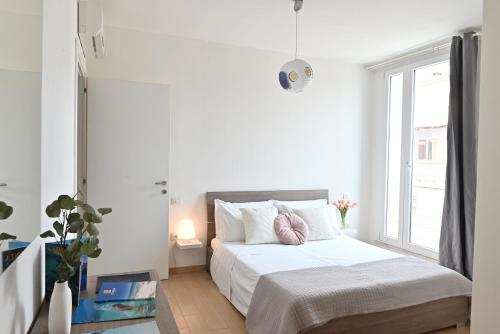 une chambre blanche avec un lit et une fenêtre dans l'établissement IzzHome Oasis, à Pula