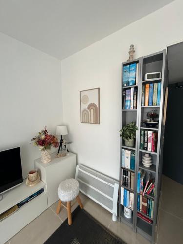 a living room with a book shelf and a desk at Studio Zilte Rust - Zeedijk Middelkerke in Mellet