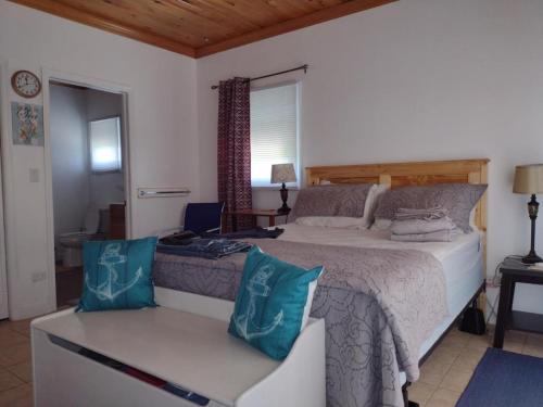 a bedroom with a large bed and a chair at Cabanya Azul on the Hill with view of the Atlantic in Buckleys