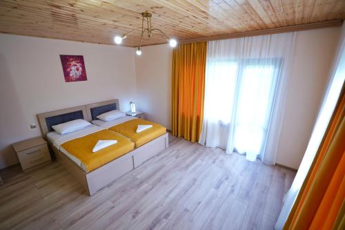 a bedroom with a bed and a large window at Hotel 5 Mountains in Mestia