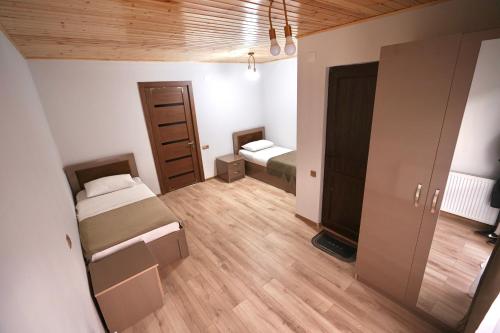 a small room with two beds and a mirror at Hotel 5 Mountains in Mestia