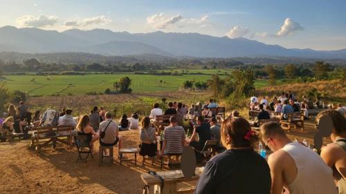 a crowd of people sitting in chairs on a hill at Bless You Hostel in Pai