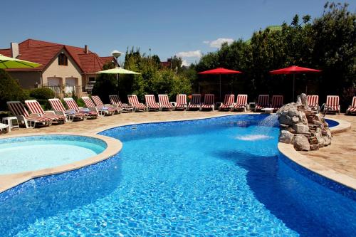 a large swimming pool with chairs and umbrellas at Veles Hotel in Fontanka