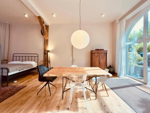 a dining room with a table and a bed at Villa Schloss Rimsingen Fine Apartments in Breisach am Rhein