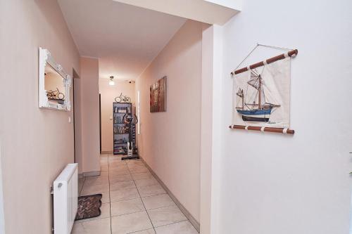 a hallway with a painting of a boat on the wall at CLIFF House in Międzyzdroje