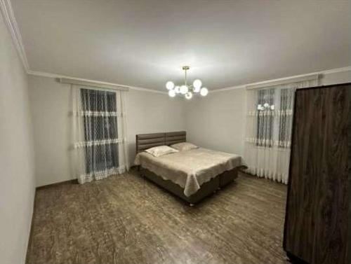 ein Schlafzimmer mit einem Bett und einem Kronleuchter in der Unterkunft Chakvi Guest House in Chakvi