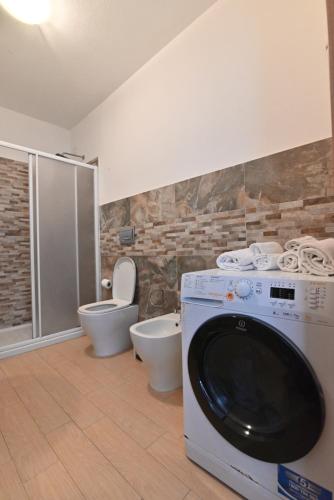 une salle de bains avec lave-linge et toilettes dans l'établissement IzzHome Oasis, à Pula