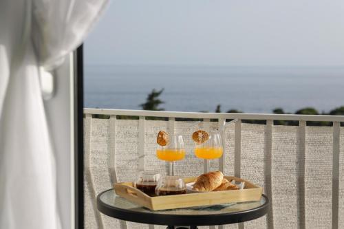 einen Tisch mit Gläsern Orangensaft und Brot auf dem Balkon in der Unterkunft Studio Andrea in Dubrovnik