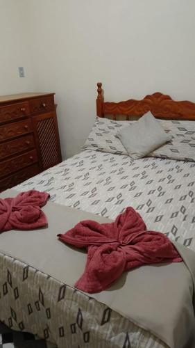 a bed with two red towels on it at Paraíso dás águas in Botelhos