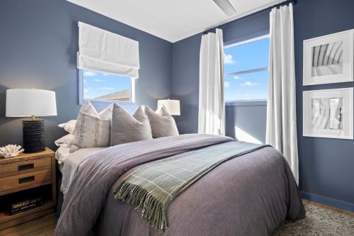 a bedroom with a bed with blue walls and a window at The Morgan in Gulf Shores