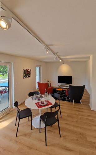 a living room with a table and chairs at Ferienwohnung in Wilnsdorf OT Wilden neu erstellt & hochwertig in Wilnsdorf