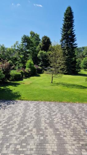 a brick walkway with a park in the background at Ferienwohnung in Wilnsdorf OT Wilden neu erstellt & hochwertig in Wilnsdorf