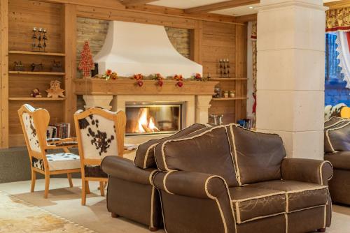 a living room with a couch and a fireplace at Residence Anda in Pozza di Fassa