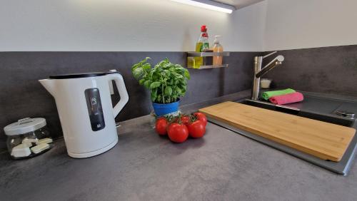 a kitchen with a counter with tomatoes and a sink at Ferienwohnung in Wilnsdorf OT Wilden neu erstellt & hochwertig in Wilnsdorf