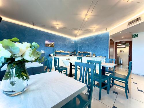 a restaurant with tables and chairs and a vase of flowers at Serpa Hotel in Anzio