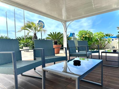 a group of chairs on a deck with a table at Serpa Hotel in Anzio
