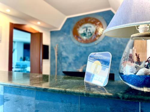 a cell phone sitting on a counter next to a fish bowl at Serpa Hotel in Anzio