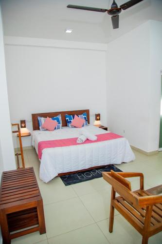 a bedroom with a large bed and a chair at Ocean Villa Den in Galle