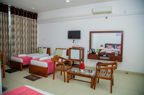a living room with a bed and a mirror at Ocean Villa Den in Galle