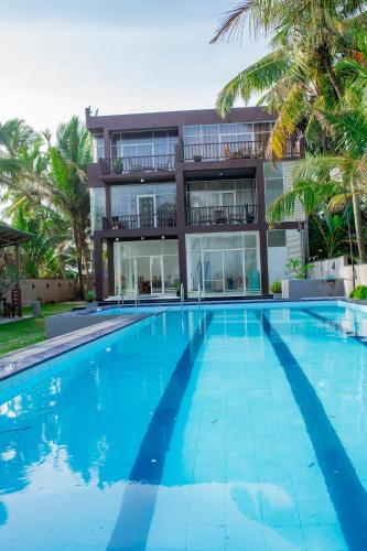a large swimming pool in front of a building at Ocean Villa Den in Galle