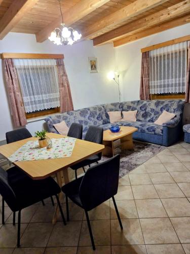 a living room with a couch and a table and chairs at Mölltaler Ferienhäuser in Großkirchheim