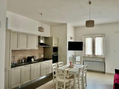 a kitchen with white cabinets and a table and chairs at Casa Vacanze 'La Quercia' in Cisternino