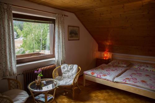 ein Schlafzimmer mit einem Bett und einem Tisch und einem Fenster in der Unterkunft Apartments & Rooms Smučka in Kranjska Gora