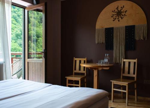 a bedroom with a bed and a table and chairs at Daravand Restaurant & Guest House in Dilijan