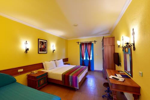 a hotel room with a bed and a desk and a bed sidx sidx at Jasmin Beach Hotel in Gümbet