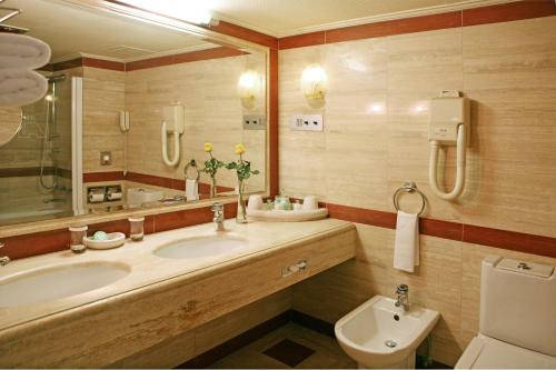a bathroom with a sink and a tub and a toilet at Katriya Hotel and Tower in Hyderabad