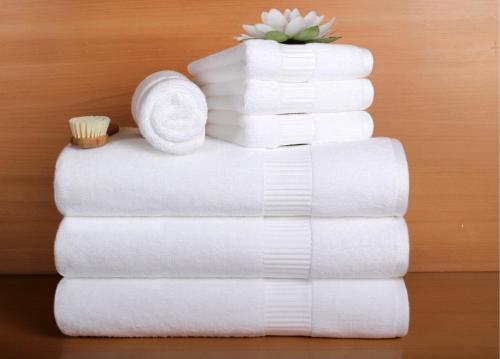 a stack of white towels with a flower on top at Katriya Hotel and Tower in Hyderabad