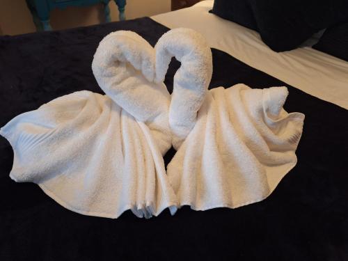 two towel swans sitting on top of a bed at Fryers Cottage 3 Bedroom Sleeps 6 Cottage in Scarborough