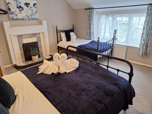 two beds in a room with a fireplace at Fryers Cottage 3 Bedroom Sleeps 6 Cottage in Scarborough