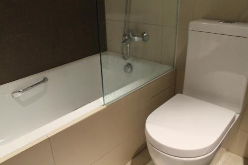a bathroom with a toilet and a tub with a shower at Katriya Hotel and Tower in Hyderabad
