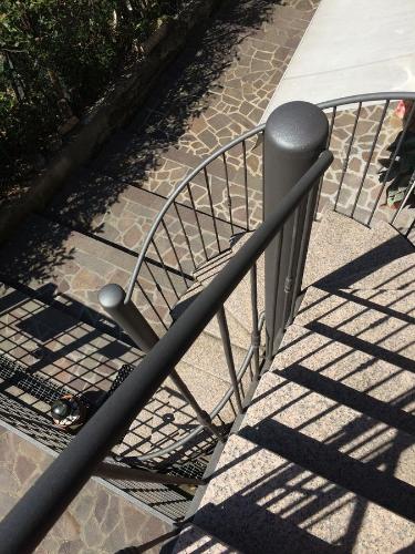 a metal railing next to a staircase with its shadow at Rustico di Benellini Angela in Polpenazze del Garda