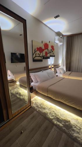 a bedroom with two beds and a large mirror at Italia Hotel cairo in Cairo