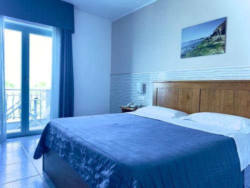 a bedroom with a large bed with a blue light at Serpa Hotel in Anzio