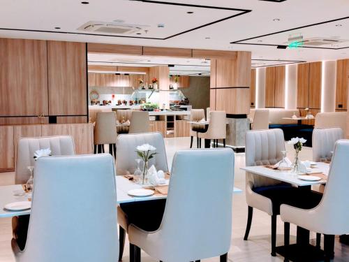a restaurant with white tables and white chairs at Elite Haven in Al Madinah