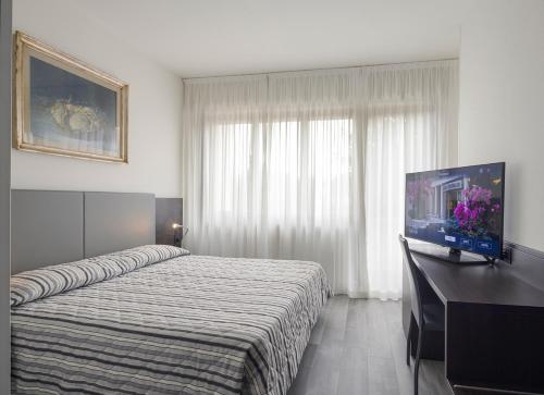 a hotel room with a bed and a flat screen tv at Hotel Cristallo in Conegliano