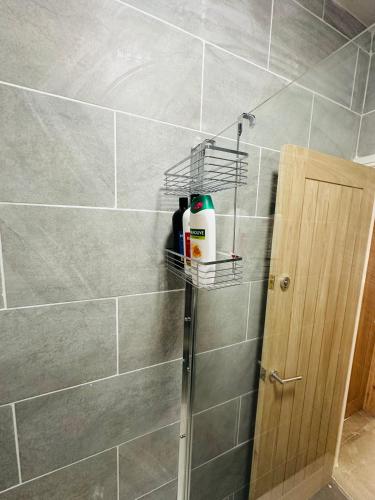 a bathroom with a shower with a shelf on the wall at Burton Urban Apartment A in Burton upon Trent
