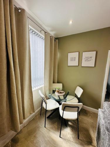 a dining room with a glass table and chairs at Burton Urban Apartment A in Burton upon Trent