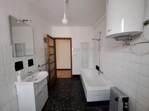 a white bathroom with a tub and a sink at BLACK DOLOMYTE Apartment in Schilpario