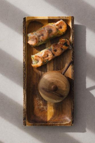 a wooden tray with sausages and a wooden spoon at Pousada Maria Flor in Fernando de Noronha