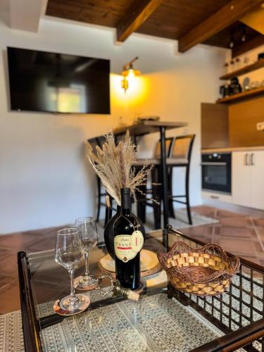 a glass table with a bottle of wine and glasses at The Fairy Valley Villa Boutique in Pluzine