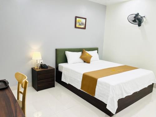 a bedroom with a large bed and a night stand at Sunrise Airport Hotel - Noi Bai Airport in Thach Loi