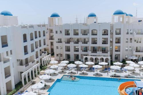 Luftaufnahme eines Hotels mit Pool und Sonnenschirmen in der Unterkunft Santorini Resort apartment in Dawwār Shindī Fannūsh