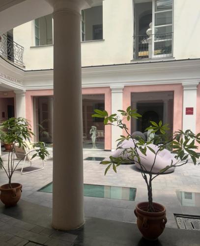 a column in the middle of a building with plants at Hotel Terme Neronensis in Pozzuoli